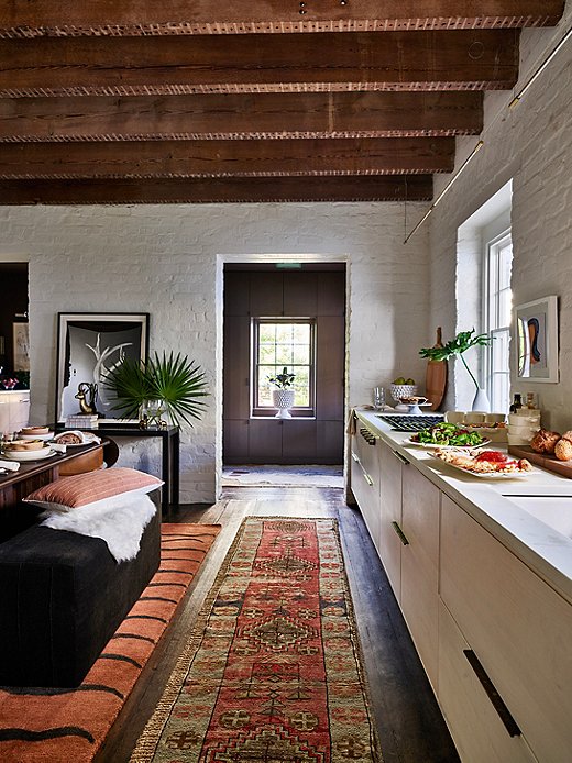 Many Oushak, Boujad, and other Asian and African rugs feature earthy colors and geometric motifs that complement Southwestern style. The simple, spare lines of the dark wood furniture also fit in with the look.
